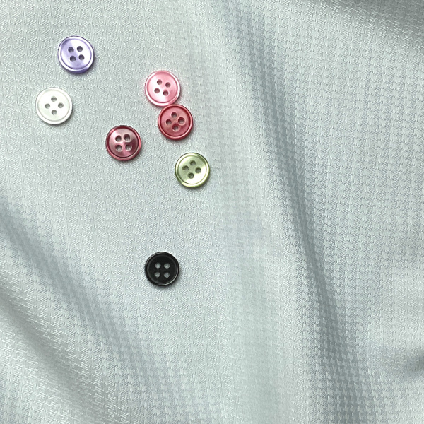 ボタンと薄ブルー特殊の生地